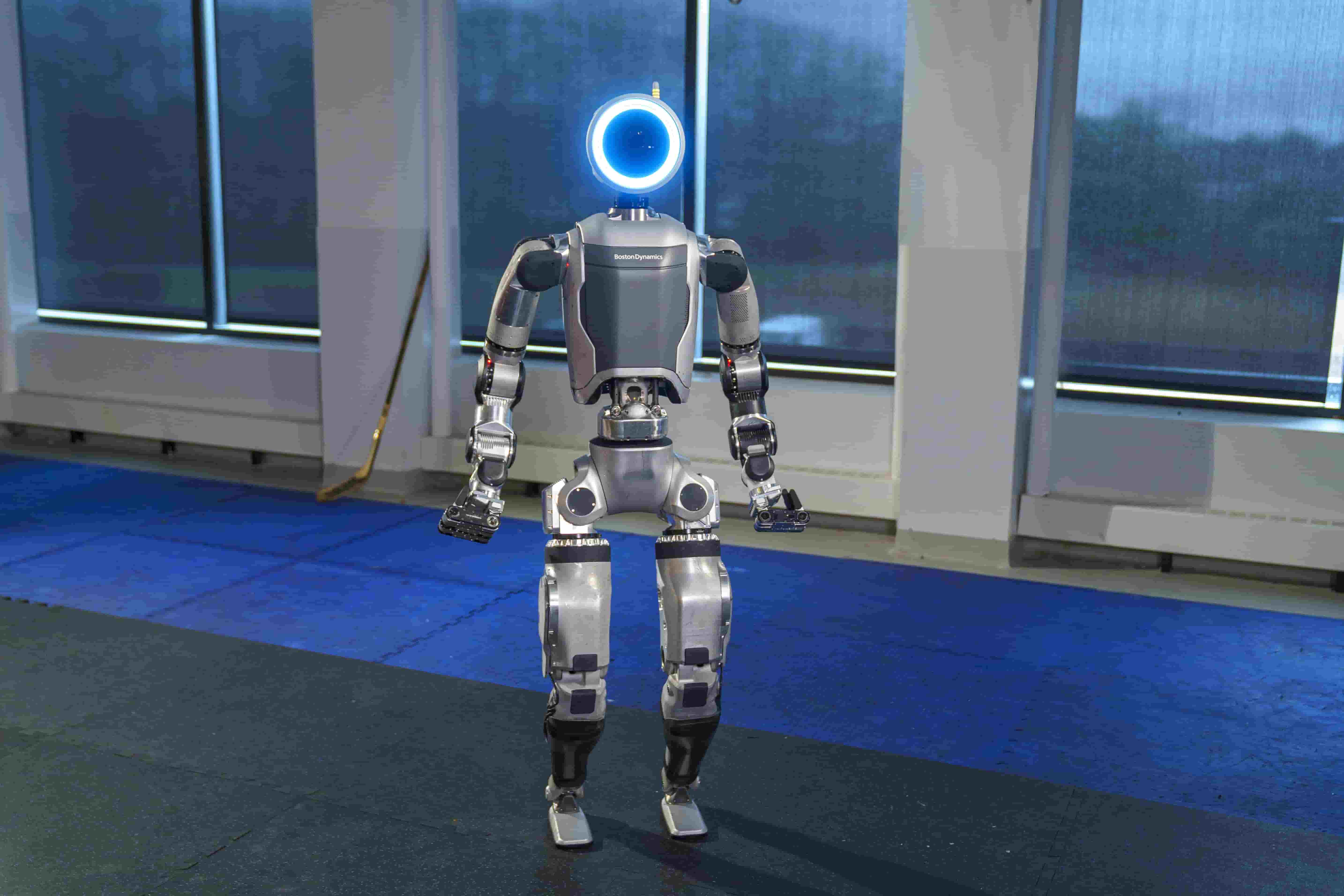 A silver and grey humanoid robot stands with a glowing blue circle for its head.